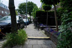 Een elektrische auto laadt op via een kabel over de stoep – een groeiend straatbeeld in Nederlandse steden