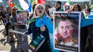 Demonstrant presenteert een foto van de zoon van de voormalige shah van Iran. Bron: ANP